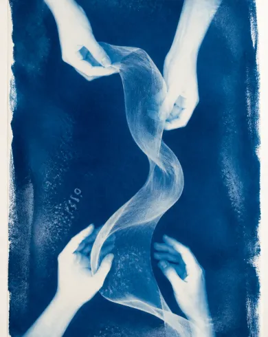 Sun-exposed cyanotype / cotton rag paper artwork depicting the cyanotype silhouettes of two pairs of real hands supporting a wave-shaped translucent cloth. The vertical composition keeps the subject clear and preserves authentic craft texture.